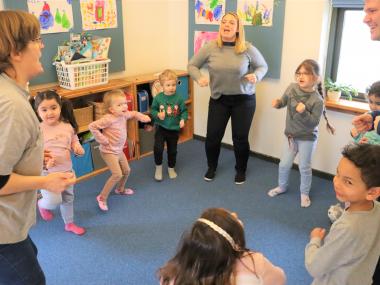 Pædagoger og børn har sang- og bevægelsesleg