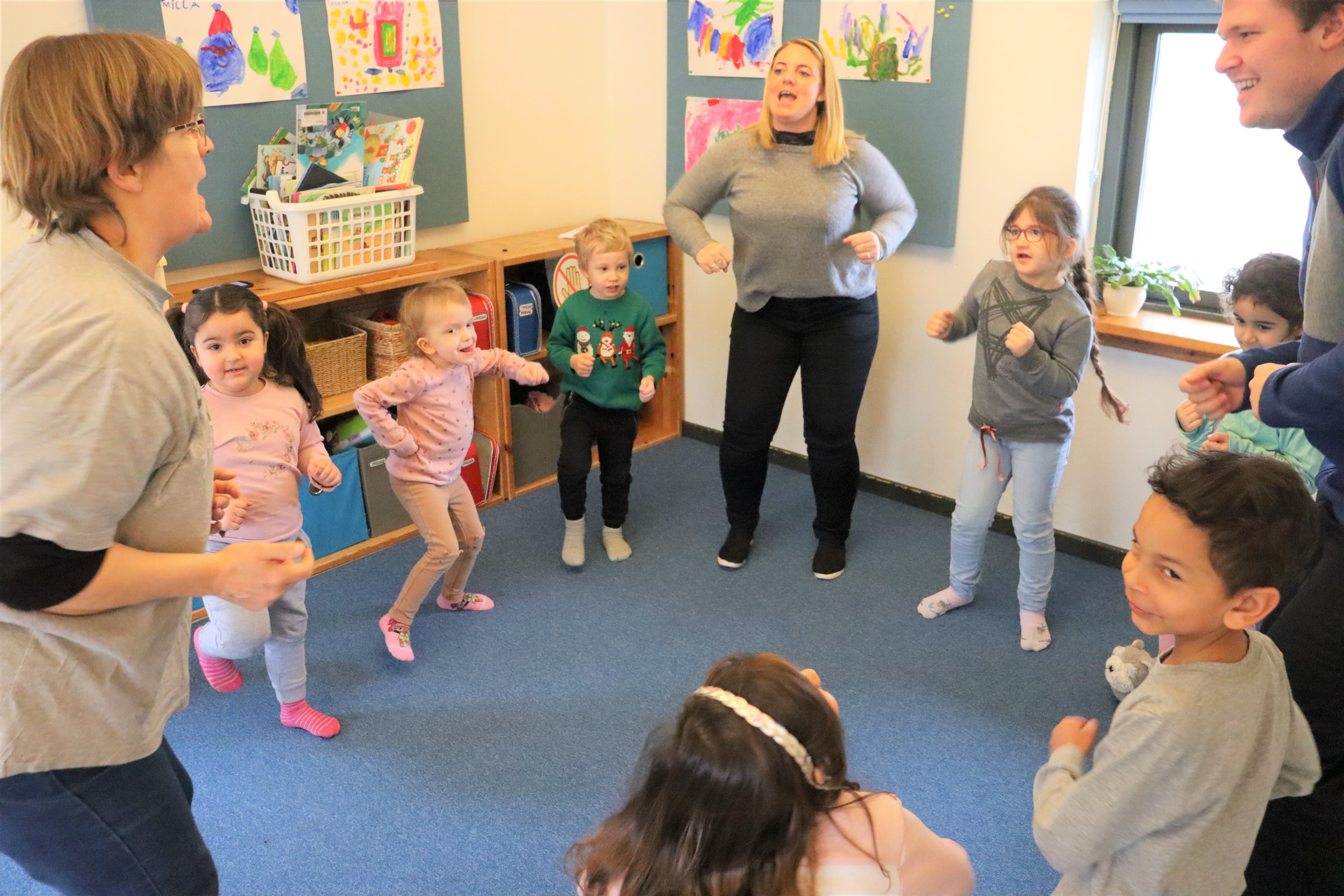 Pædagoger og børn danser rundt og synger